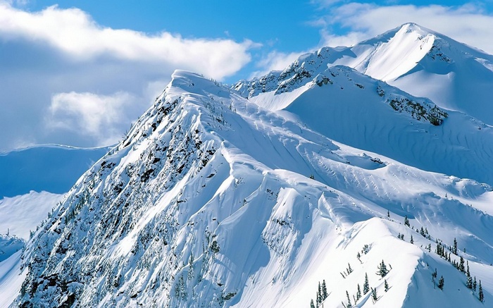 Snow-covered mountain range under a blue sky