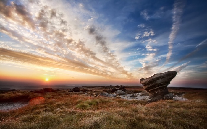 Sunrise over a rocky moorland with dramatic clouds