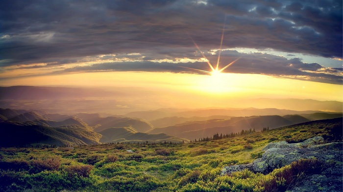 Sunrise over rolling hills and mountains