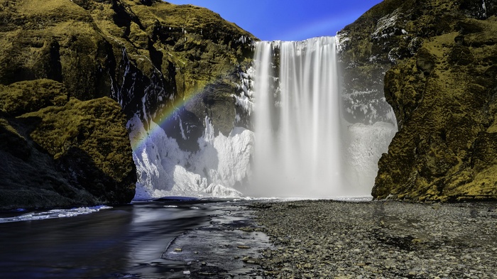 Skogafoss waterfall with rainbow in Iceland
