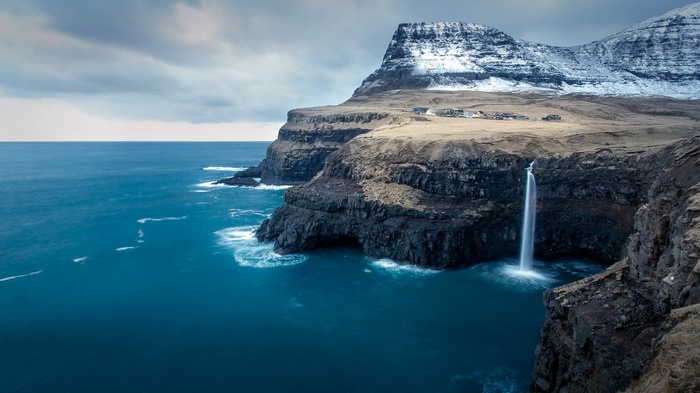 Waterfall cascading from cliffs into the ocean