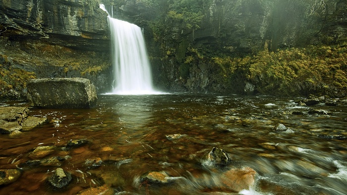 Waterfall cascading into a rocky river