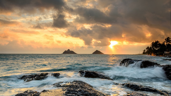 Sunrise over the ocean with islands and rocky shore