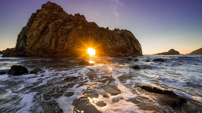 Sunset through a rock arch at Pfeiffer Beach