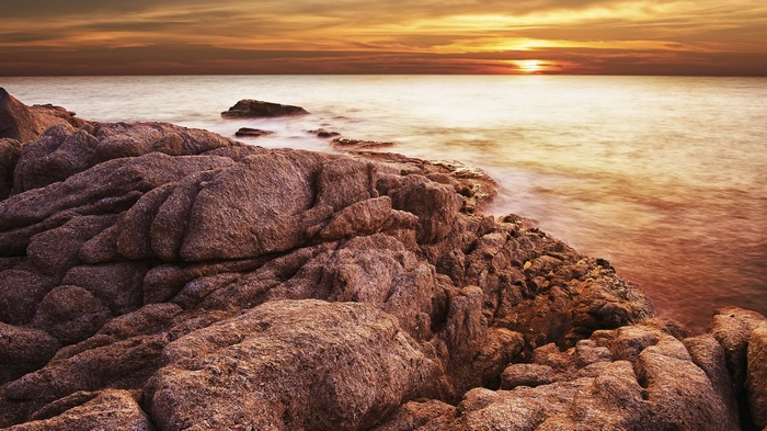 Rocky coastline at sunset over the ocean