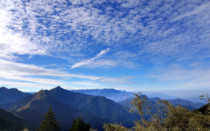 Mountain range under a cloudy blue sky