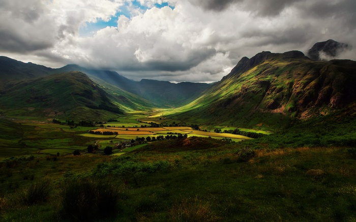Valley with green hills and dramatic clouds