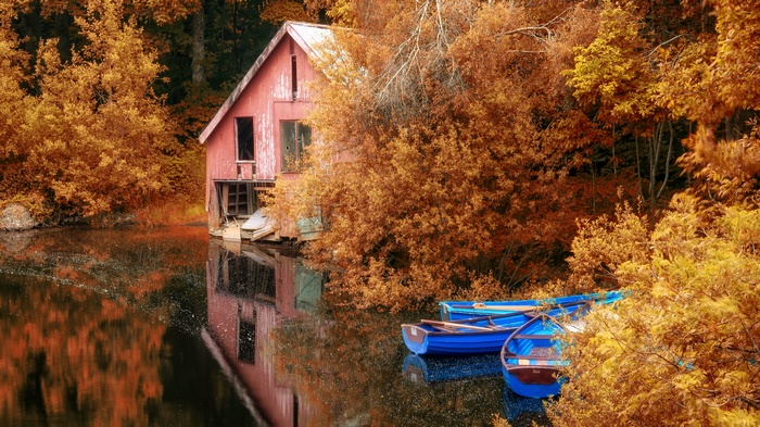 Boathouse and boats on a lake in autumn