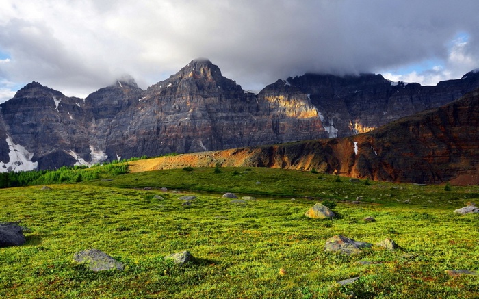 Rocky Mountains with Green Meadow and Clouds