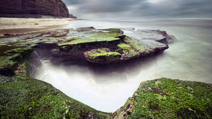 Mossy rocks and ocean waves at a rocky coastline