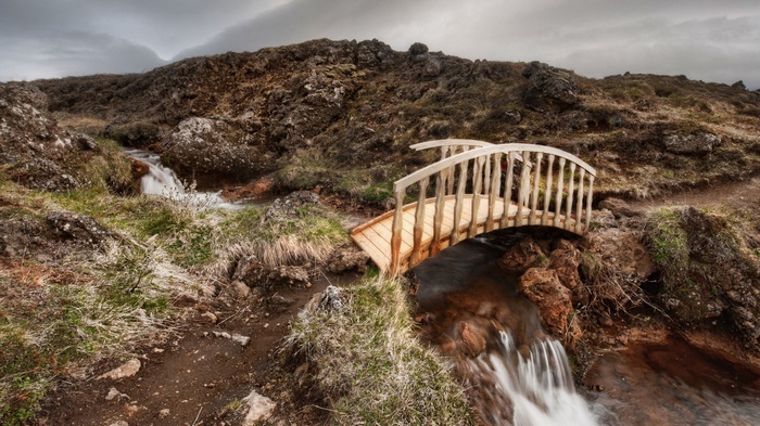 Wooden bridge over a stream in a rocky landscape