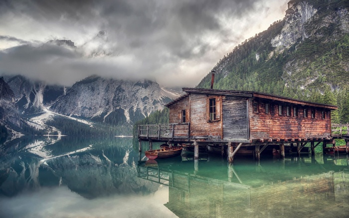 Wooden boathouse on a lake with mountains