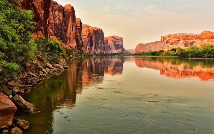 River flowing between sandstone cliffs with reflections