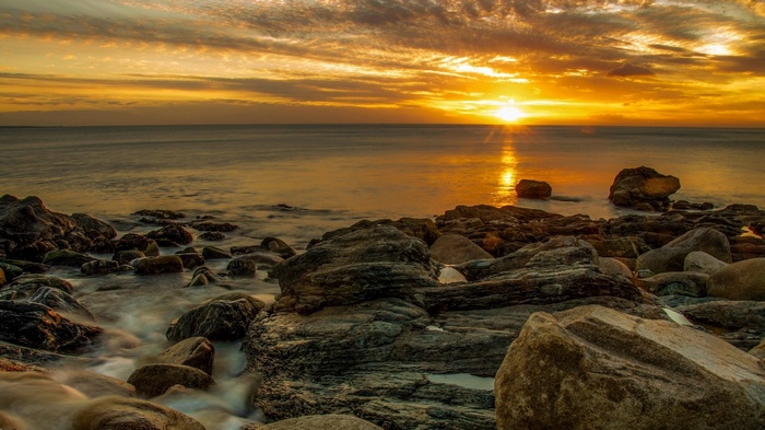 Sunset over rocky ocean shore