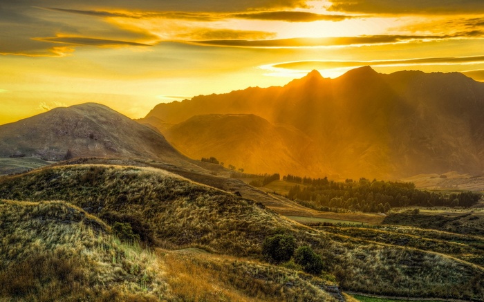 Golden sunset over rolling hills and mountains