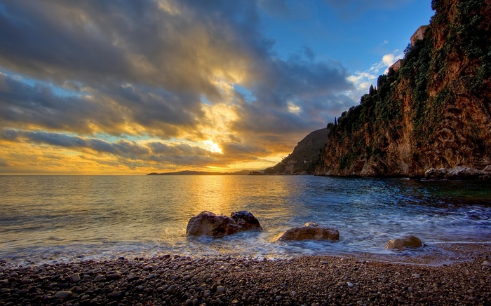 Sunset over a rocky coastline with cliffs and ocean