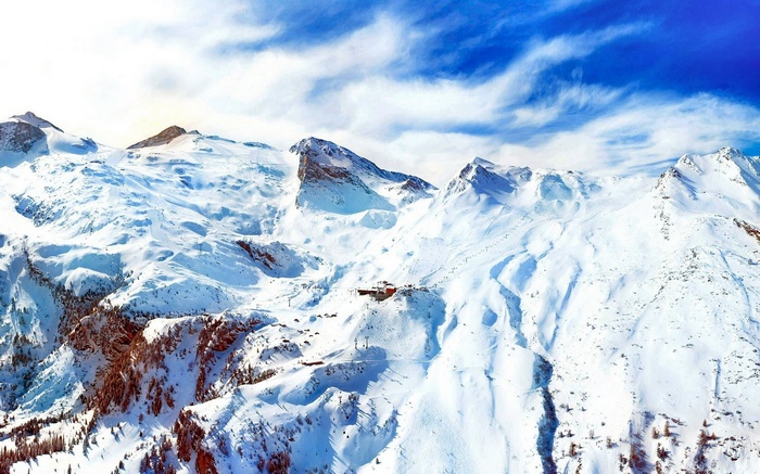Snowy mountains with ski resort buildings and ski lifts