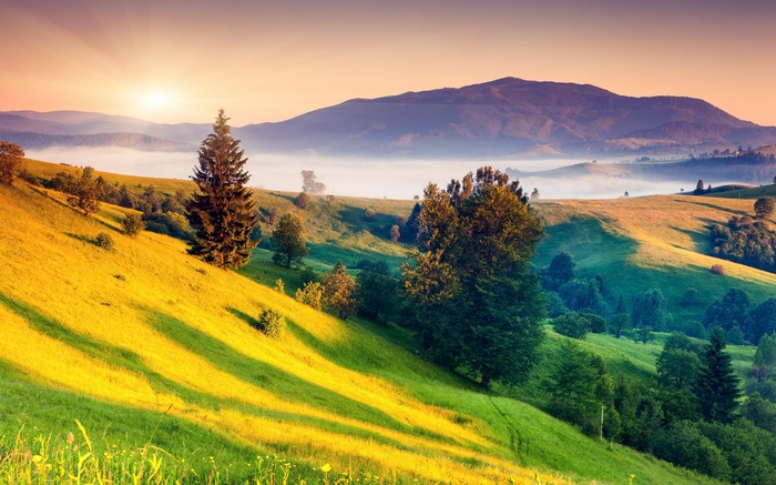 Sunrise over misty mountains and rolling hills