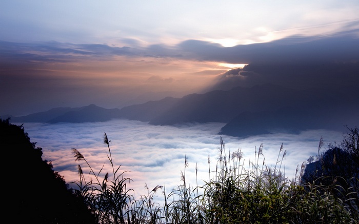 Sea of clouds over mountains at sunrise