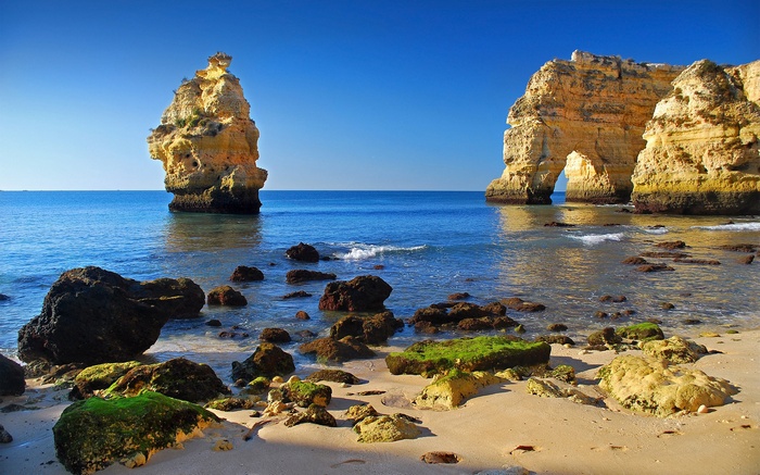 Beach with rock formations and clear blue ocean