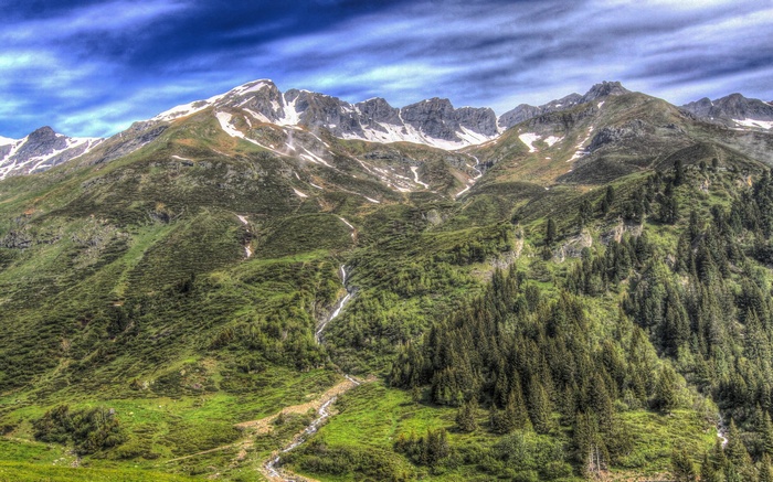 Mountain range with green slopes and snow-capped peaks