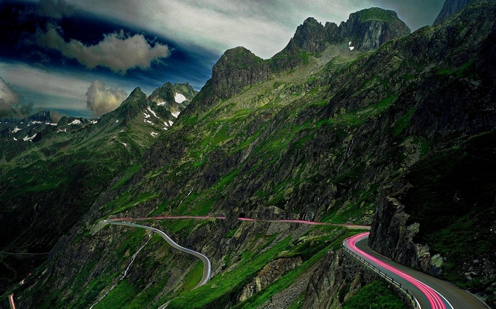 Mountain pass with winding road and light trails