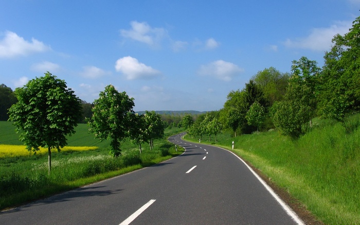 Winding road through green countryside under blue sky
