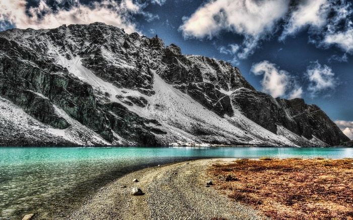Turquoise lake at the base of a snow-dusted mountain