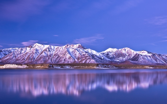 Snow-capped mountains reflected in a calm lake