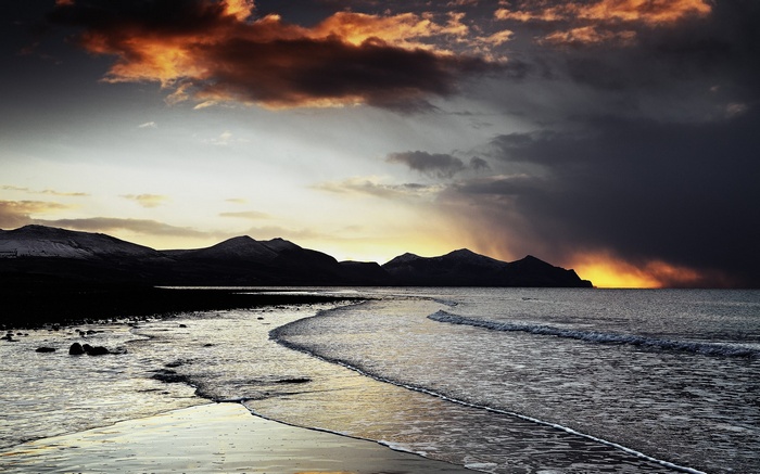 Sunset over a rocky beach and mountains