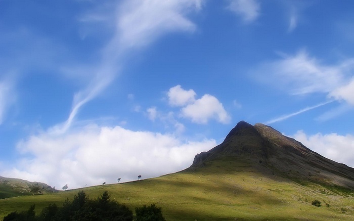 Mountain peak under a blue sky with clouds