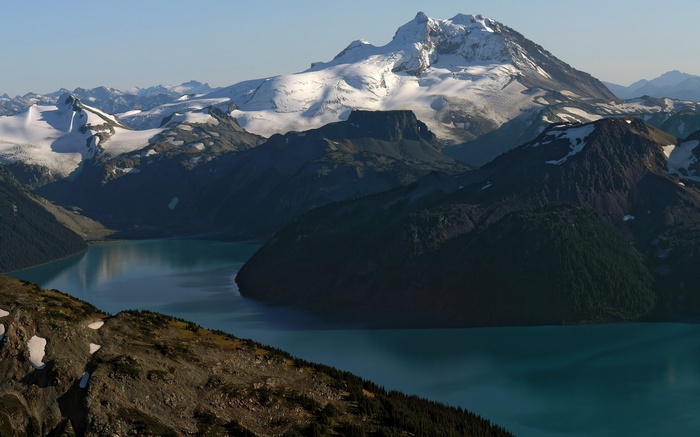 Snow-capped mountains overlooking a turquoise lake