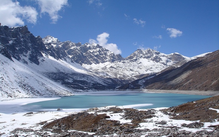 Turquoise lake surrounded by snow-capped mountains