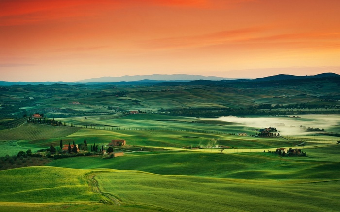 Rolling green hills of Tuscany at sunrise