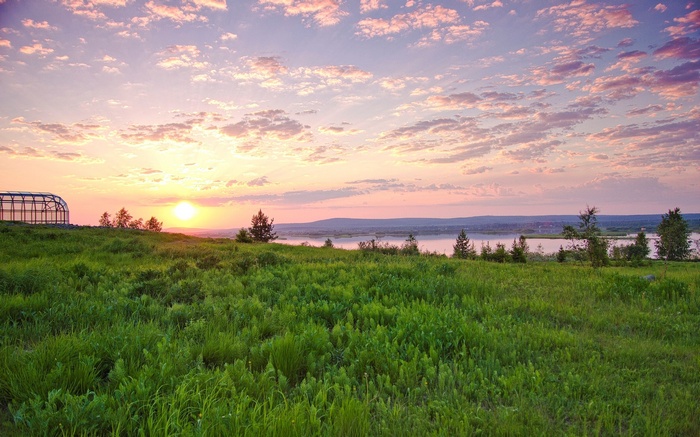 Sunset over a grassy field and river