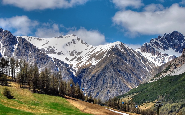 Cable cars ascend a snowy mountain valley