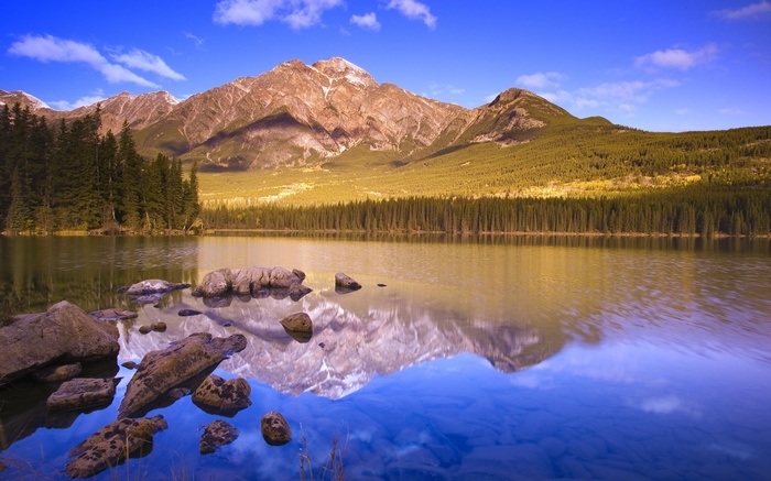 Mountain reflection in a clear lake with rocks