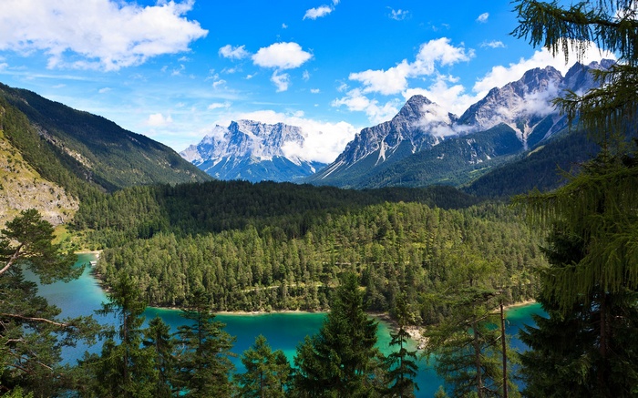 Turquoise lake surrounded by pine forest and mountains