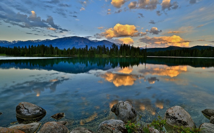 Lake reflection of mountains and clouds at sunset
