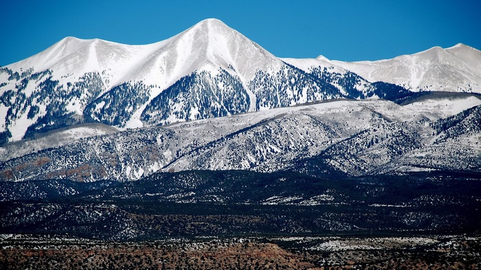 Snow-covered mountains under a clear blue sky
