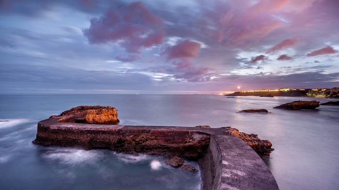 Coastal town with lighthouse at sunset
