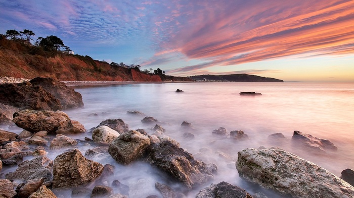 Rocky beach at sunset with colorful clouds