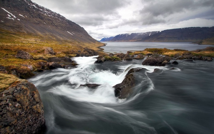 River flowing through a fjord with mountains