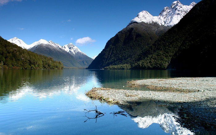 Snow-capped mountains reflected in a clear lake