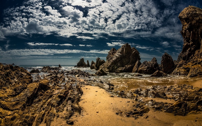 Rocky coastline with dramatic clouds and ocean waves