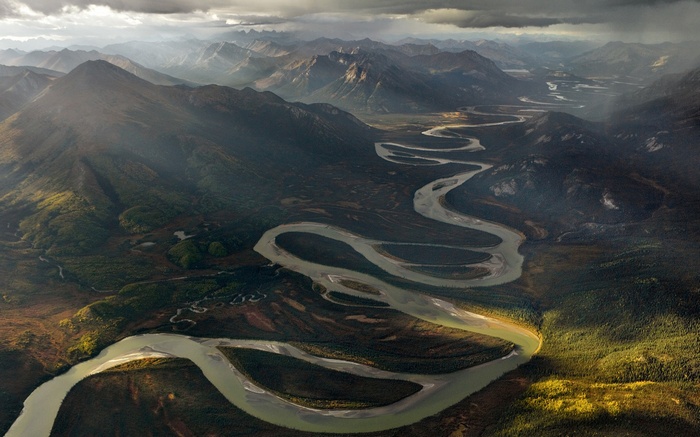 Aerial view of a winding river through mountains