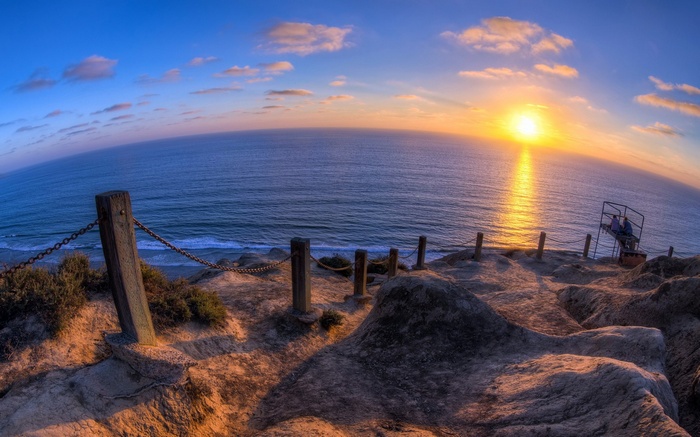 Sunset over the ocean with a cliffside path