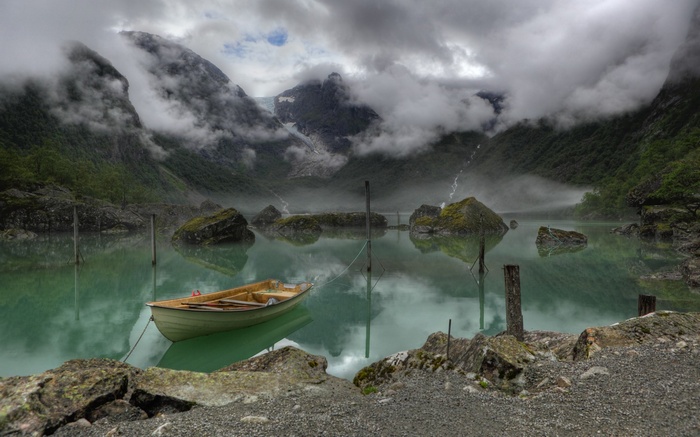 Boat on a misty lake with mountains