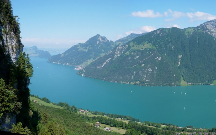 Turquoise lake surrounded by green mountains and cliffs