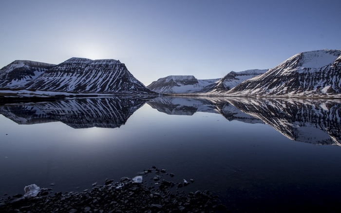 Snow-capped mountains reflected in a calm lake